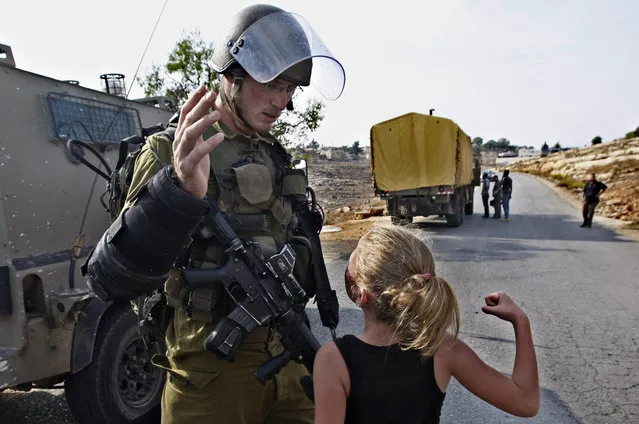 In this November 2, 2012 file photo, then 12-year-old Ahed Tamimi tries to punch an Israeli soldier during a protest in the West Bank village of Nabi Saleh. Tamimi is to go on trial Tuesday, February 13, 2018, before an Israeli military court, for slapping and punching two Israeli soldiers in December. Palestinians say her actions embody their David vs. Goliath struggle against a brutal military occupation, while Israel portrays them as a staged provocation meant to embarrass its military. Tamimi is one of an estimated 350 Palestinian minors in Israeli jails. (Photo by Majdi Mohammed/AP Photo)