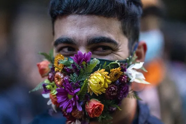 A person smiles as he wears a face mask amid of new coronavirus pandemic during the Diversity parade in Montevideo, Uruguay, Friday, September 25, 2020. The event is held every year to raise awareness and fight against discrimination based on sexual identity and orientation. (Photo by Matilde Campodonico/AP Photo)