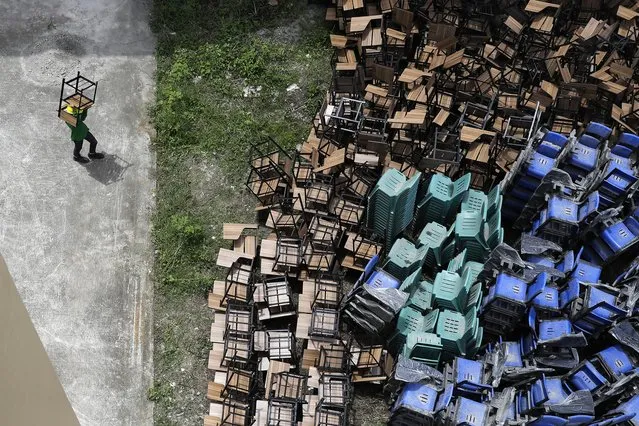 A worker arranges chairs as they temporarily convert a public school to a COVID-19 quarantine facility in Quezon city, Philippines on Tuesday, September 1, 2020, as the government further eased lockdown restrictions despite the country having the most coronavirus infections in Southeast Asia. (Photo by Aaron Favila/AP Photo)