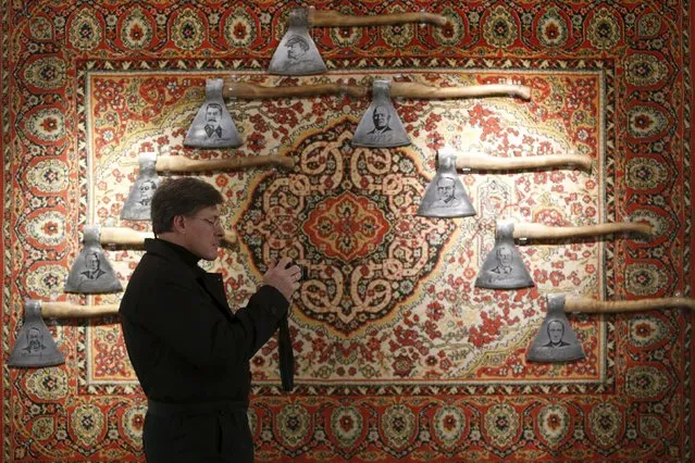 A man takes a photo next to the art installation "History of Russia in axes" by Russian artist Vasily Slonov during an exhibition titled "Quilted cavaliers of the apocalypse" at the Winzavod center of contemporary art in Moscow, Russia October 24, 2015. (Photo by Sergei Karpukhin/Reuters)