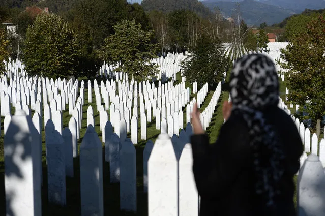 A woman prays at the memorial cemetery in Potocari, after the first public showing of Bosnian filmmaker Jasmila Zbanic's film on the 1995 massacre in Srebrenica – “Quo Vadis, Aida?”, in the eastern Bosnian town of Srebrenica, October 10, 2020. The Srebrenica massacre was the culmination of Bosnia's 1992-95 war, which pitted the country's three main ethnic factions – Serbs, Croats and Bosnian Muslims. (Photo by Kemal Softic/AP Photo)