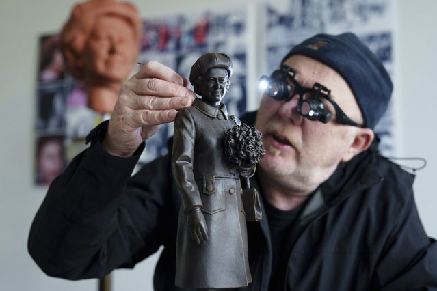 Staffordshire sculptor Andy Edwards poses for a picture while fine-tuning a scale model of his statue of Queen Elizabeth II commissioned by Newcastle-under-Lyme Borough Council to mark the borough's 850th anniversary, Newcastle-Under-Lyme, England, Thursday, April 18, 2024. Edwards whose previous works include the landmark Beatles statue at Liverpool's Pier Head, is basing the sculpture on photographs of the late Queen's visit to Newcastle-under-Lyme as part of the Borough's 800th anniversary celebrations in 1973. (Photo by Jon Super/AP Photo)