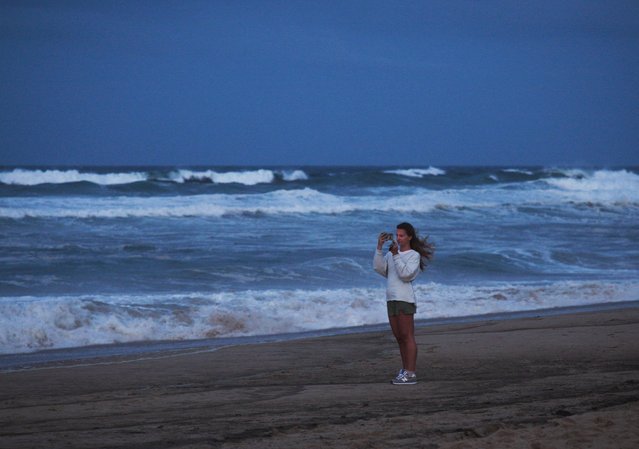 A woman takes pictures of the waves before Hurricane Erin's near approach, in Kitty Hawk, North Carolina, U.S. August 20, 2025. (Photo by Maria Alejandra Cardona/Reuters)