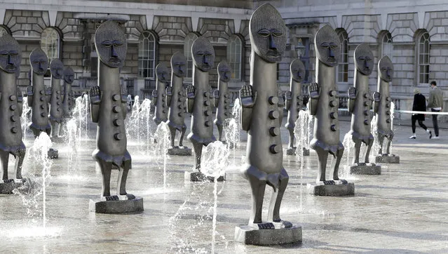 The fountains flow around an installation by artist Zak Ove, of a Nubian army of masked men as they stand in the courtyard at Somerset House in London, Tuesday, October 4, 2016. The unveiling of Ove’s resin and Jesmonite statues marks the launch of the 1:54 Art Fair.  (Photo by Kirsty Wigglesworth/AP Photo)