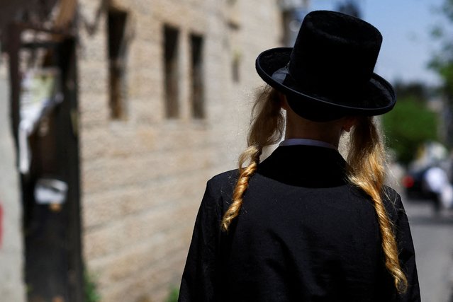 An Ultra-Orthodox Jewish person walks, ahead of the Jewish holiday of Passover, in Jerusalem's Mea Shearim neighbourhood on April 21, 2024. (Photo by Hannah Mckay/Reuters)