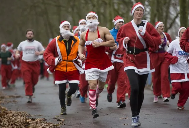 Runners dressed in Santa Claus outfits compete in the annual Santa Run in Victoria Park, east London December 7, 2014. (Photo by Neil Hall/Reuters)