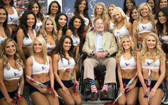 Former U.S. president George Bush, father of George W. Bush poses with new cheerleaders of the football team Houston Texans, in Houston, Texas, on April 18, 2013. (Photo by Smiley N. Pool/AP Photo/Houston Chronicle)