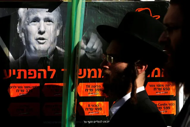 Ultra-Orthodox Jewish man walk next to a poster of Donald Trump in Jerusalem's Mea Shearim neighbourhood, October 13, 2016. (Photo by Amir Cohen/Reuters)