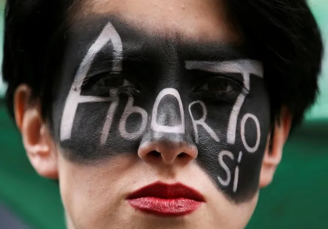 A woman with the slogan “Abortion, yes” painted on her face demonstrates in front of Colombia's constitutional court in support of removing abortion from the penal code, in Bogota, Colombia February 3, 2022. (Photo by Luisa Gonzalez/Reuters)