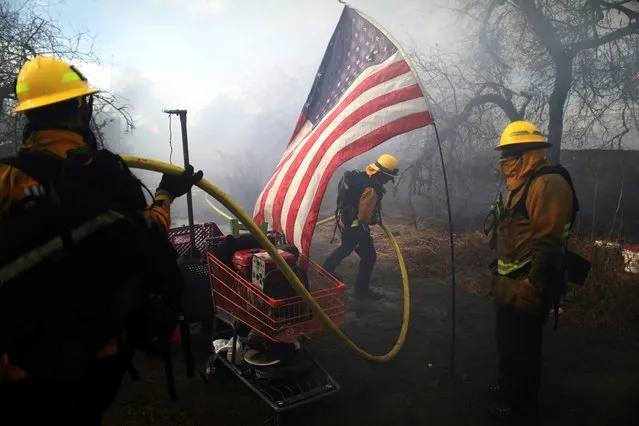 Firefighters tackle a blaze at a homeless encampment in Montebello, California, U.S. December 8, 2020. (Photo by David Swanson/Reuters)