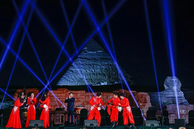 In this picture taken on April 3, 2023, members of the China National Traditional Orchestra perform during a concert on the plateau of the Great Pyramids of Giza on the outskirts of Cairo. (Photo by Khaled Desouki/AFP Photo)