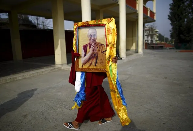 A Tibetan monk carries a portrait of exiled Tibetan spiritual leader, the Dalai Lama, during a function organised to mark "Losar" or the Tibetan New Year, in Kathmandu in this March 4, 2014 file photo. (Photo by Navesh Chitrakar/Reuters)