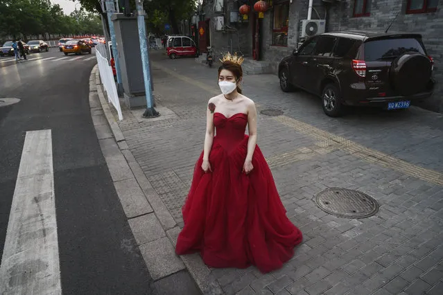 A Chinese woman wears her dress and a protective mask as she waits to change after taking pictures in advance of her wedding near the Forbidden City, on April 30, 2020 in Beijing, China. Beijing lowered its risk level after more than three months Thursday in advance of the May holiday, allowing most domestic travellers arriving in the city to do so without having to do 14 days of quarantine. The Forbidden City will open to a limited number of visitors as of Thursday morning. After decades of growth, officials said China's economy had shrunk in the latest quarter due to the impact of the coronavirus epidemic. The slump in the world's second largest economy is regarded as a sign of difficult times ahead for the global economy. While industrial sectors in China are showing signs of reviving production, a majority of private companies are operating at only 50% capacity, according to analysts. With the pandemic hitting hard across the world, officially the number of coronavirus cases in China is dwindling, ever since the government imposed sweeping measures to keep the disease from spreading. Officials believe the worst appears to be over in China, though there are concerns of another wave of infections as the government attempts to reboot the world's second largest economy. Since January, China has recorded more than 81,000 cases of COVID-19 and at least 3,200 deaths, mostly in and around the city of Wuhan, in central Hubei province, where the outbreak first started. (Photo by Kevin Frayer/Getty Images)