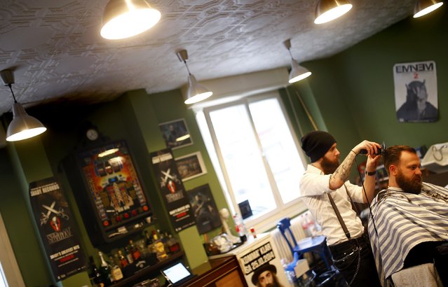 Alex “Torreto” Vellios, a 26-year old Greek-born barber concentrates while styling the hair of a customer at his Torreto barber shop in Frankfurt January 6, 2015. (Photo by Kai Pfaffenbach/Reuters)