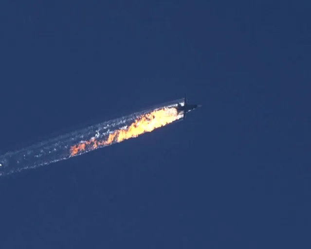 A still image made available on 24 November 2015 from video footage shown by the HaberTurk TV Channel shows a burning trail as a plane comes down after being shot down near the Turkish-Syrian border, over north Syria, 24 November 2015. A Russian fighter jet was shot down 24 November over the Turkish-Syrian border, the Defence Ministry in Moscow said, according to Interfax news agency. (Photo by EPA/Haberturk TV Channel)