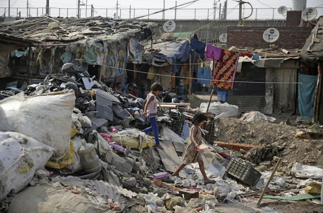 In this photo taken June 1, 2018, young girls climb down from a heap of plastic garbage, near a garbage dump in New Delhi, India. India will host U.N. World Environment Day on June 5. This year’s theme is “Beat Plastic Pollution”. (Photo by Altaf Qadri/AP Photo)