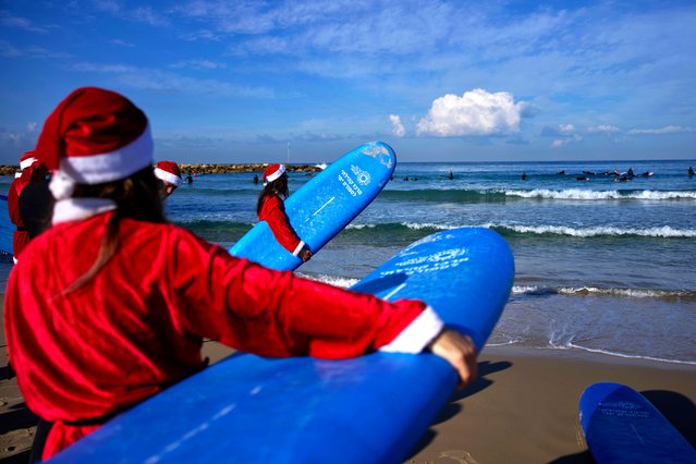 Surfers dressed as Santa Claus gather on the beach while filming an advertisement for tourism ahead of Christmas, in Tel Aviv, Israel, Tuesday, December 2, 2025. (Photo by Ohad Zwigenberg/AP Photo)