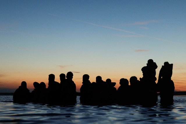 Migrants wade into the water in Gravelines, France, to get to a “taxi boat” as they look to cross the English Channel at dawn on Friday, September 19, 2025. (Photo by Dan Kitwood/Getty Images)