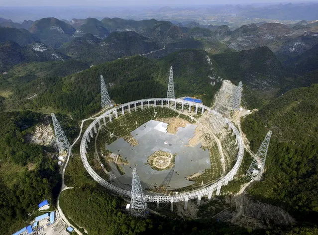 A 500-metre (1,640-ft.) aperture spherical telescope is seen under construction among the mountains in Pingtang county, Guizhou province, China, November 26, 2015. The telescope, which will be the largest in the world, will be put in use by September 2016, according to local media. (Photo by Reuters/Stringer)