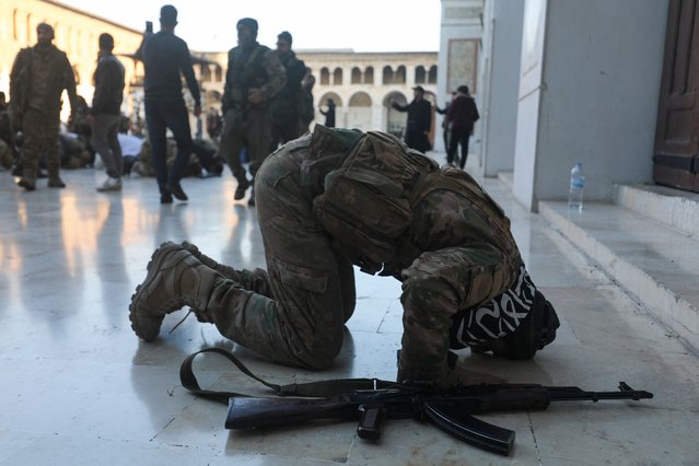 An anti-government fighter prays in the courtyard of Damascus' historic Umayyad mosque on December 8, 2024, after Islamist-led rebels declared that they have taken the Syrian capital in a lightning offensive, sending President Bashar al-Assad fleeing and ending five decades of Baath rule in Syria. (Photo by Abdulaziz Ketaz/AFP Photo)