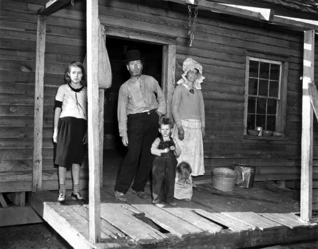 Sharecropper Wesley Prickett, his wife and three children pose on the porch of their dilapidated farmhouse in Keysvill, Ga., on December 23, 1936 during the Great Depression.  Left to right, Mary Lucille, Wesley, Franklin Delano (Dude), Mary Anne and Mrs. Prickett. (Photo by AP Photo)