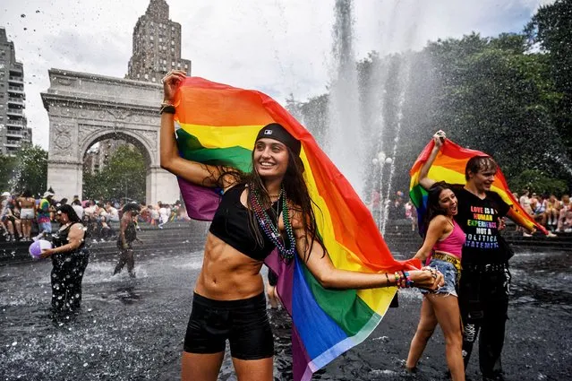 People enjoy a fountain in Washington Square park during the annual New York Pride march in New York on June 25, 2023. (Photo by Ed Jones/AFP Photo)