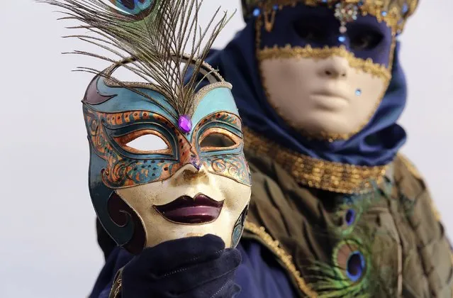 A masked reveller poses in front of St. Mark's square during the first day of carnival in Venice February 1, 2015. (Photo by Stefano Rellandini/Reuters)