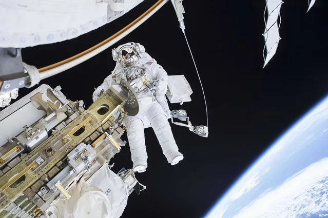 Expedition 46 Flight Engineer Tim Kopra performs a spacewalk outside the International Space Station in this December 21, 2015 NASA handout photo. Kopra and Expedition 46 Commander Scott Kelly successfully moved the International Space Station's mobile transporter rail car ahead of the December 23, 2015 docking of a Russian cargo supply spacecraft. (Photo by Reuters/NASA)