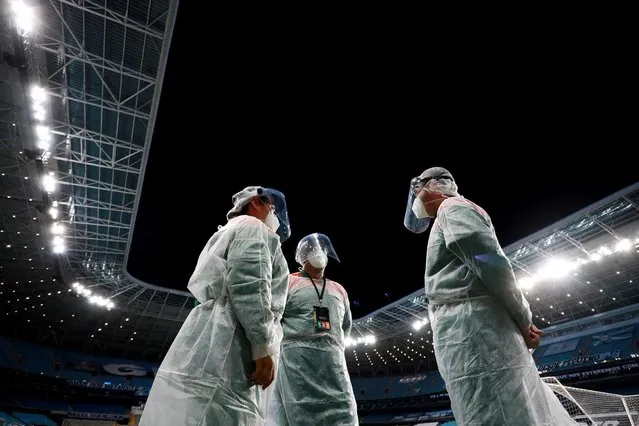 Staff wearing protective gear before the first leg match of second stage of Copa CONMEBOL Libertadores 2021 between Gremio and Ayacucho at Arena do Gremio on March 10, 2021 in Porto Alegre, Brazil. (Photo by Silvio Avila/Reuters)