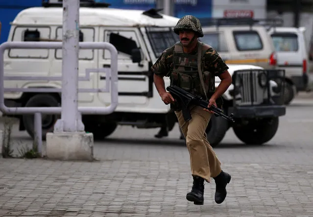 An Indian policeman runs near the site of a shootout in which a Central Reserve Police Force (CRPF) officer was killed, in Srinagar July 24, 2018. (Photo by Danish Ismail/Reuters)