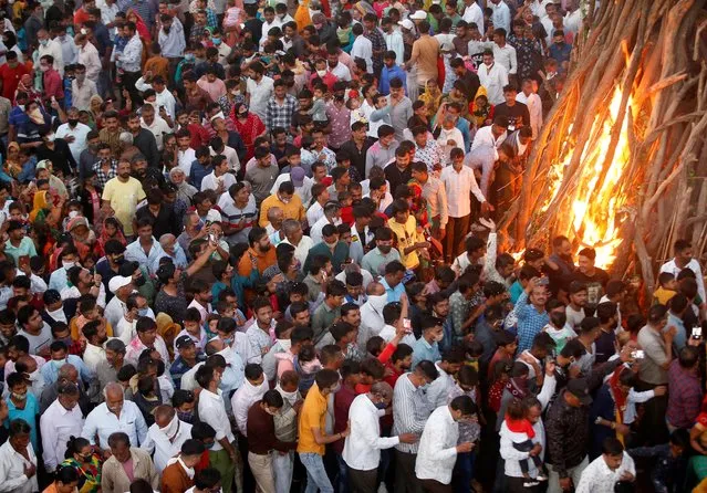 Hindu devotees walk around a bonfire during a ritual known as “Holika Dahan” which is part of the Holi festival, in Ahmedabad, India, March 28, 2021. (Photo by Amit Dave/Reuters)