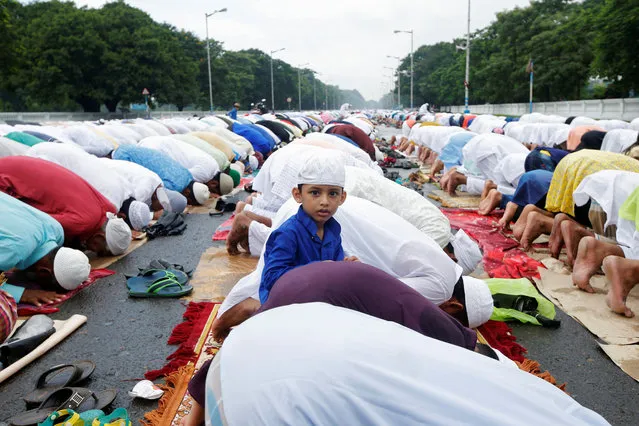 A boy looks on as Muslims offer Eid al-Adha prayers on a street in Kolkata, August 22, 2018. (Photo by Rupak De Chowdhuri/Reuters)