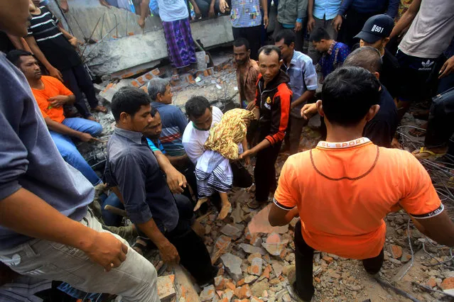 The body of a young earthquake victim is carried in Pidie Jaya, Aceh province on December 7, 2016. At least 52 people died and dozens were feared trapped in rubble after a strong earthquake struck off Aceh province on Indonesia's Sumatra island on December 7, officials said. (Photo by Aqien Abdullah/AFP Photo)
