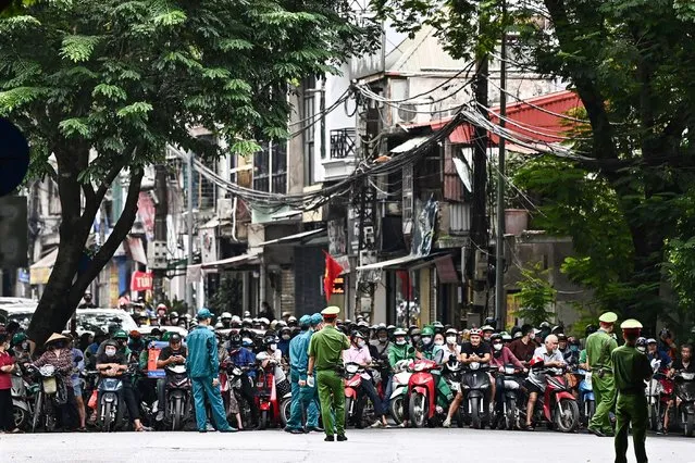 Drivers wait as the road is blocked for the convoy carrying US President Joe Biden in Hanoi on September 11, 2023, following a 2-day visit to Vietnam. (Photo by Nhac Nguyen/AFP Photo)