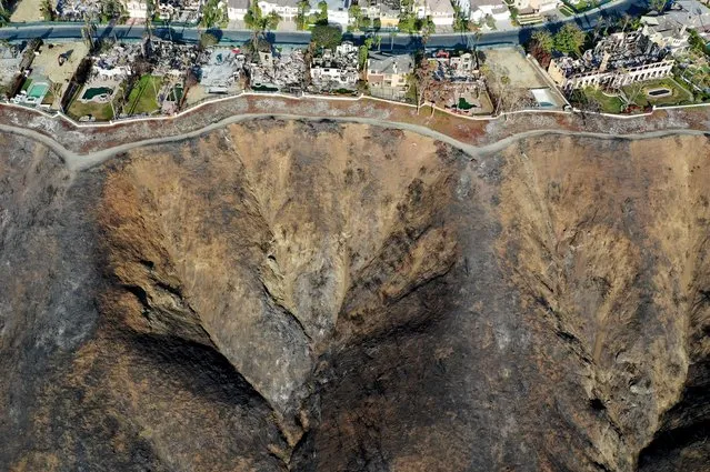 An aerial view of some of the 20 hillside homes destroyed by the Coastal Fire as cleanup work continues on June 17, 2022 in Laguna Niguel, California. The May 11 brush fire was fueled by windy and dry conditions amid California’s severe drought, which has been compounded by climate change. Flames raced up the hill to reach the multimillion-dollar houses after the fire started below in a nearby canyon. (Photo by Mario Tama/Getty Images)
