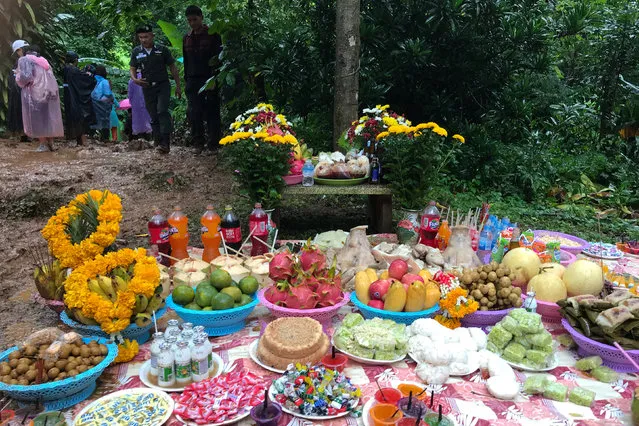 Fruits, desserts and drinks are placed as offerings to the spirits near the Tham Luang caves, where 12 members of an under-16 soccer team and their coach are trapped, in the northern province of Chiang Rai, Thailand, June 26, 2018. (Photo by Chayut Setboonsarng/Reuters)