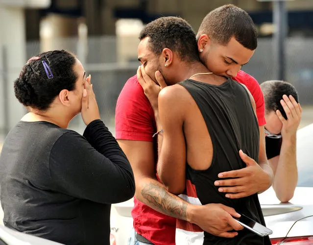 Friends and family members embrace outside the Orlando Police Headquarters during the investigation of a shooting at the Pulse night club, where as many as 20 people have been injured after a gunman opened fire, in Orlando, Florida, June 12, 2016. (Photo by Steve Nesius/Reuters)
