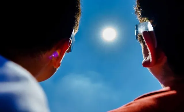 Pupils of primary school IBS Ababil, look at the solar eclipse with special glasses, in Schiedam, The Netherlands, 10 June 2021. For the first time since 2015, a partial solar eclipse can be seen again, with the sun partly obscured by the moon. (Photo by Marco de Swart/EPA/EFE)