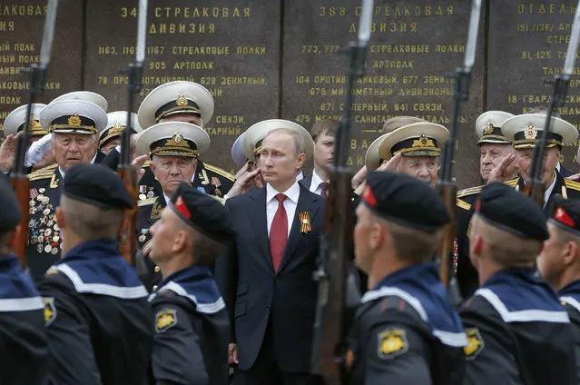 Russian President Vladimir Putin stands with military personnel during a ceremony marking Victory Day, in Sevastopol May 9, 2014. (Photo by Maxim Shemetov/Reuters)
