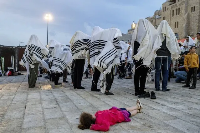 Covered in prayer shawls, Jewish men take part in priestly blessing during the weeklong holiday of Sukkot in front of the Western Wall, the holiest site where Jews can pray in Jerusalem's Old City, Monday, October 2, 2023. (Photo by Ohad Zwigenberg/AP Photo)
