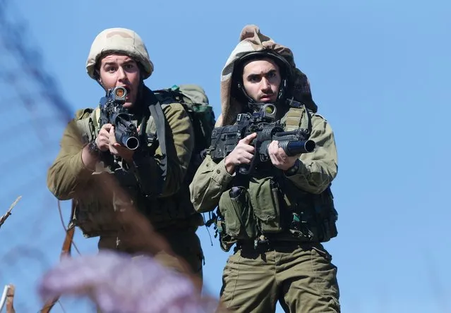 Israeli soldiers react as they secure the scene of a reported Palestinian shooting attack at a checkpoint near the Beit El settlement, close to West Bank city of Ramallah, on January 31, 2016. A Palestinian opened fire at a checkpoint near the Jewish settlement in the West Bank, wounding three Israelis before being shot dead, officials said, the latest in four months of violence. (Photo by Abbas Momani/AFP Photo)