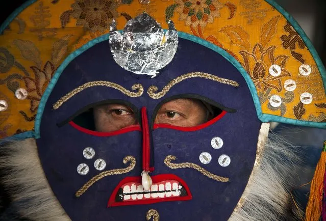 A masked Tibetan artist waits to perform a traditional opera at the Tibetan Institute of Performing Arts in Dharmsala, India, Friday, March 27, 2015. (Photo by Ashwini Bhatia/AP Photo)