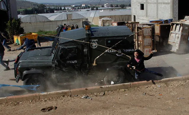 An Israeli Border Police jeep hits a Palestinian protester trying to escape during clashes at the West Bank village of Qabatiya, near Jenin, 04 February 2016. At least four Palestinians were injured, including a 16-year-old boy who was hit by a military vehicle, the mayor of the town of Qabatiya, Mahmoud Kmeil, said. Clashes erupted between Palestinian residents and the Israeli military Thursday, as forces raided the northern West Bank hometown of three militants who had launched a shooting and stabbing attack in Jerusalem the previous day. (Photo by Alaa Badarneh/EPA)