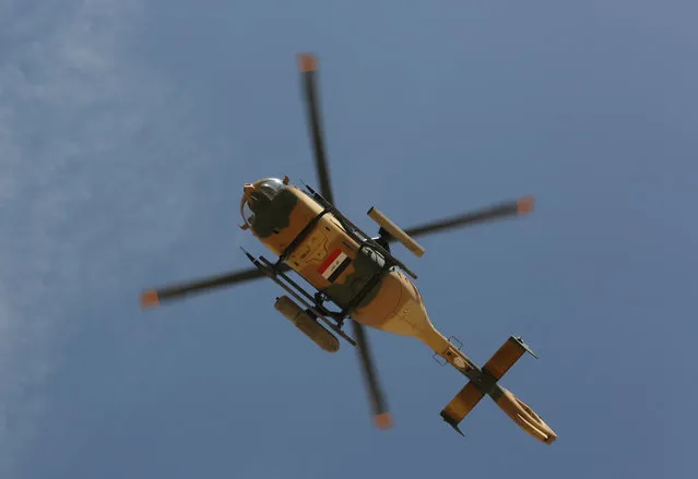 An Iraqi military helicopter prepares to attack Islamic State extremists in Tikrit, 80 miles (130 kilometers) north of Baghdad, Iraq, Tuesday, March 31, 2015. Iraqi forces battled Islamic State militants holed up in downtown Tikrit, going house to house Tuesday in search of snipers and booby traps, and the prime minister announced security forces had reached the city's center. (Photo by Khalid Mohammed/AP Photo)