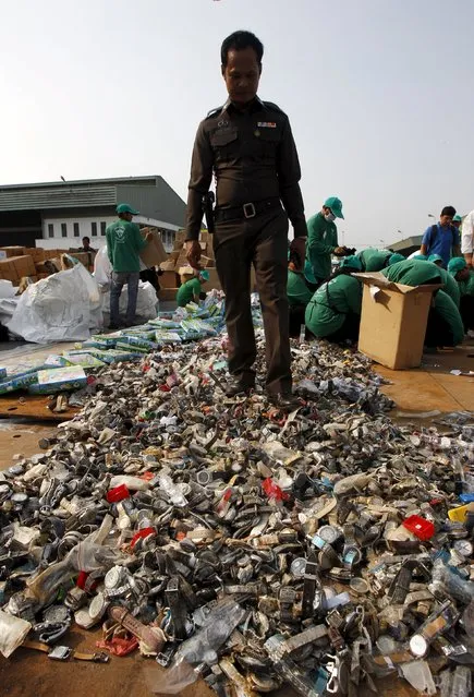 A Thai officer walks on counterfeit watches before destroying them at Khlongluang Transportation Station in Pathumtani province, on the outskirts of Bangkok April 9, 2015. (Photo by Chaiwat Subprasom/Reuters)
