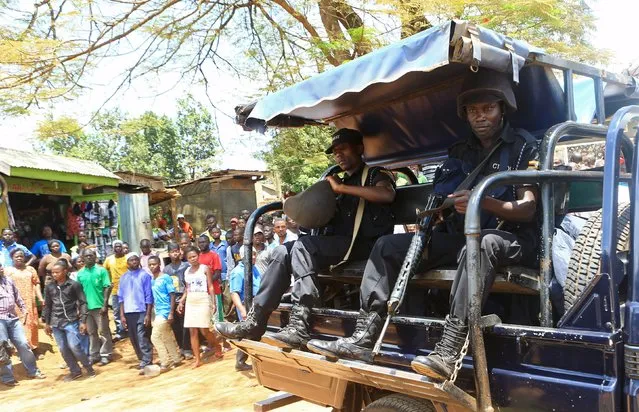 Ugandan policemen hold their weapons as they ride on the back of a truck during an arrest of people suspected of murdering Joan Kagezi, a senior Ugandan prosecutor, on the outskirts of Uganda's capital Kampala April 7, 2015. Kagezi was shot dead late on March 30, in what police said could be a targeted assassination connected to her prosecution of suspects in twin bombings in the capital Kampala claimed by the Somali Islamist rebel group al Shabaab. (Photo by James Akena/Reuters)