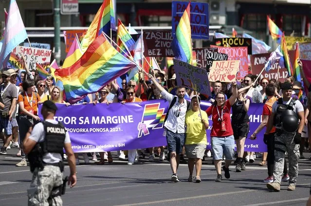 Participants walk during the annual gay pride march in the capital Sarajevo, Bosnia, Saturday, August 14, 2021. Hundreds on Saturday attended a pride march in Bosnia's capital Sarajevo with organizers saying LGBT people have been further marginalized in the impoverished and conservative Balkan nation since the start of the coronavirus pandemic. (Photo by AP Photo/Stringer)