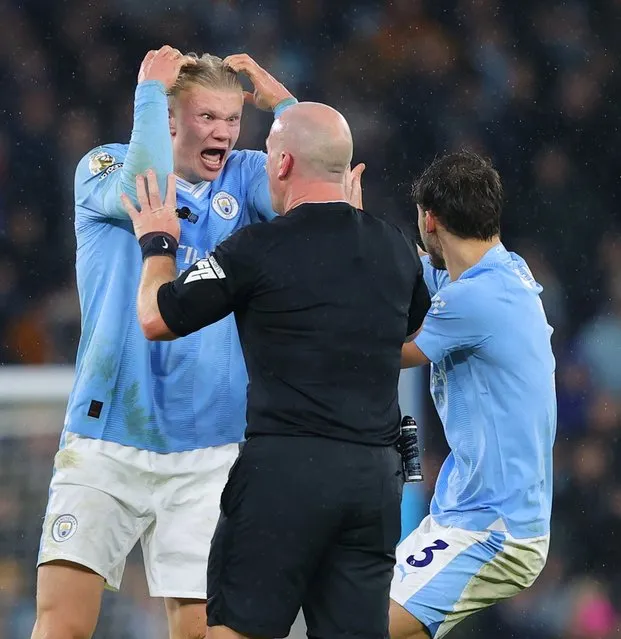 Referee Simon Hooper is surrounded by Erling Haaland, Mateo Kovacic and Ruben Dias of Manchester City after he stopped the game to award Manchester City a free kick and deny Jack Grealish (not pictured) the chance to play on and have a goal scoring chance during the Premier League match between Manchester City and Tottenham Hotspur at Etihad Stadium on December 03, 2023 in Manchester, England. (Photo by James Gill - Danehouse/Getty Images)