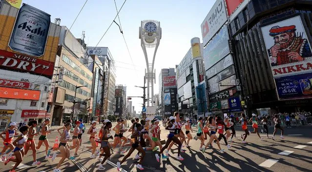 Runners run at the Susukino district while competing in the women's marathon final during the Tokyo 2020 Olympic Games in Sapporo on August 7, 2021. (Photo by Pool via AFP Photo)