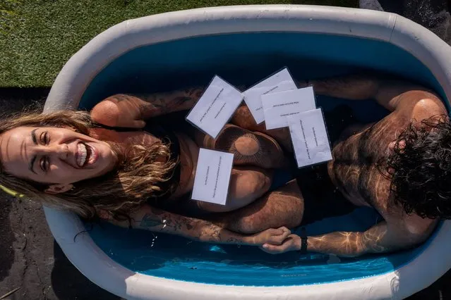 Marcela Bossia of Brazil laughs in an ice bath with Aryan Vavani of New York, as people plunge into baths of freezing cold water to help break the ice while speed dating, in Santa Monica, California, U.S., December 16, 2023. (Photo by Mike Blake/Reuters)